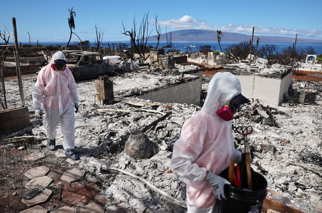 Volunteers from Samaritan's Purse help a daughter search for family items in the rubble of her mother's wildfire-damaged home on October 09, 2023, in Lahaina, Hawaii. Insured losses totaled $61.5 billion from the Hawaiian fire and convective storms during the year, according an estimate from the management consulting firm Aon.