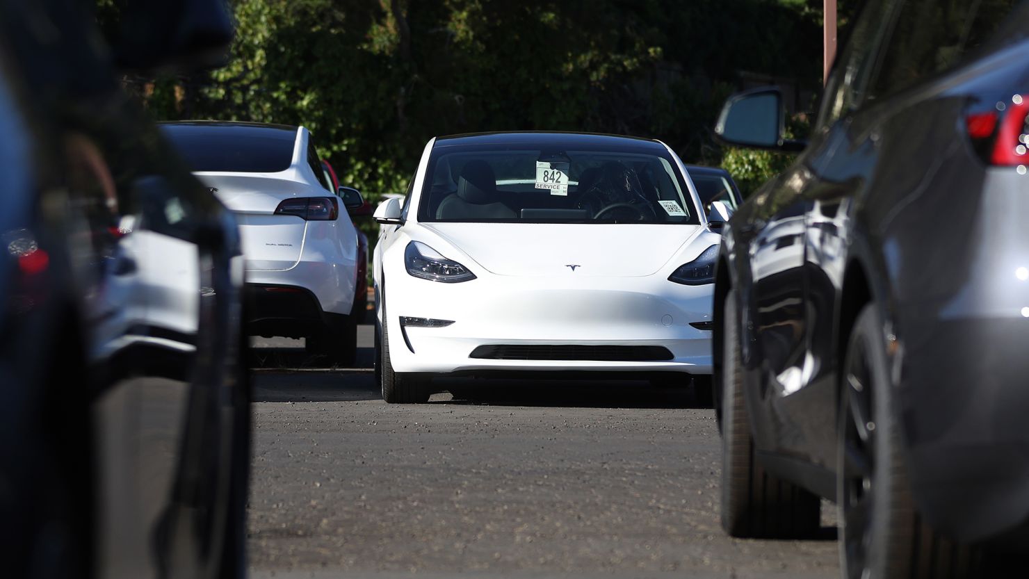 Brand new Tesla cars sit parked at a Tesla dealership on October 18, 2023 in Corte Madera, California.