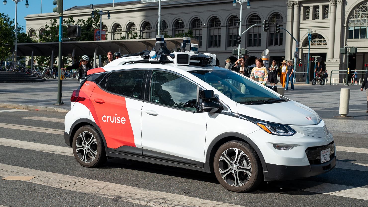 A General Motors Cruise self-driving car, often referred to as a robotaxi, drives in front of the Ferry Building on the Embarcedero, San Francisco, in 2023.