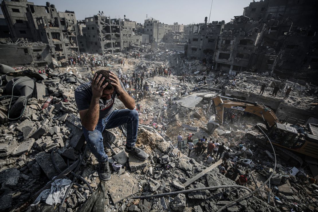 A man, sitting on debris, reacts as Palestinians conduct a search and rescue operation after a second bombardment of the Israeli army at Jabalia refugee camp in Gaza on November 1, 2023.