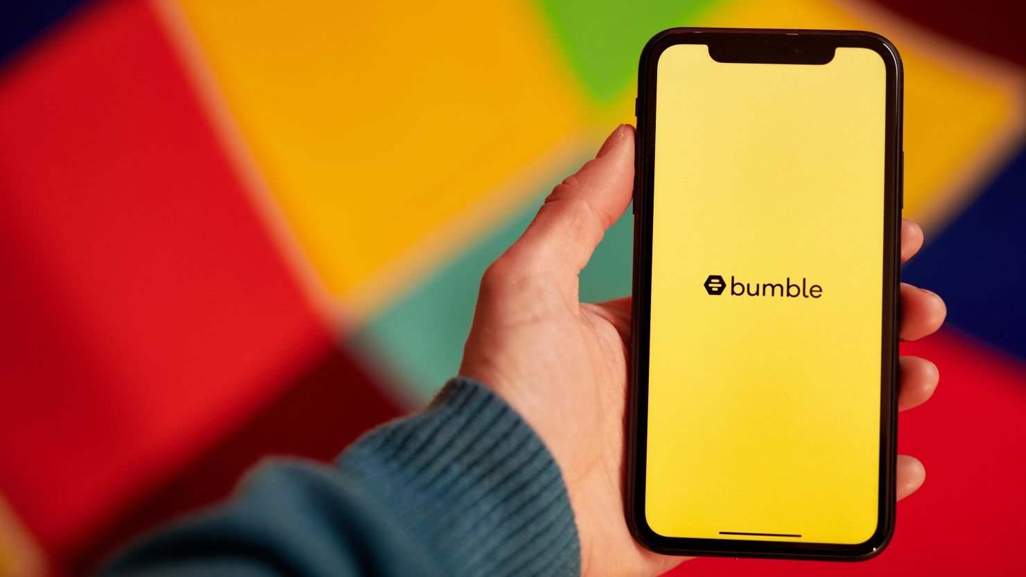 The Bumble logo shown on a smartphone. Bumble is doing away with the requirement that women message potential matches first.