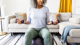 Senior woman lifting weights in living room