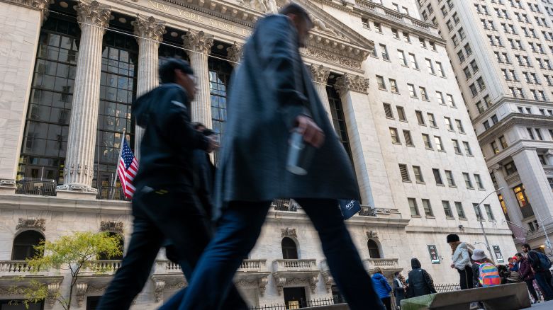 People walk by the New York Stock Exchange on November 2, in New York City.