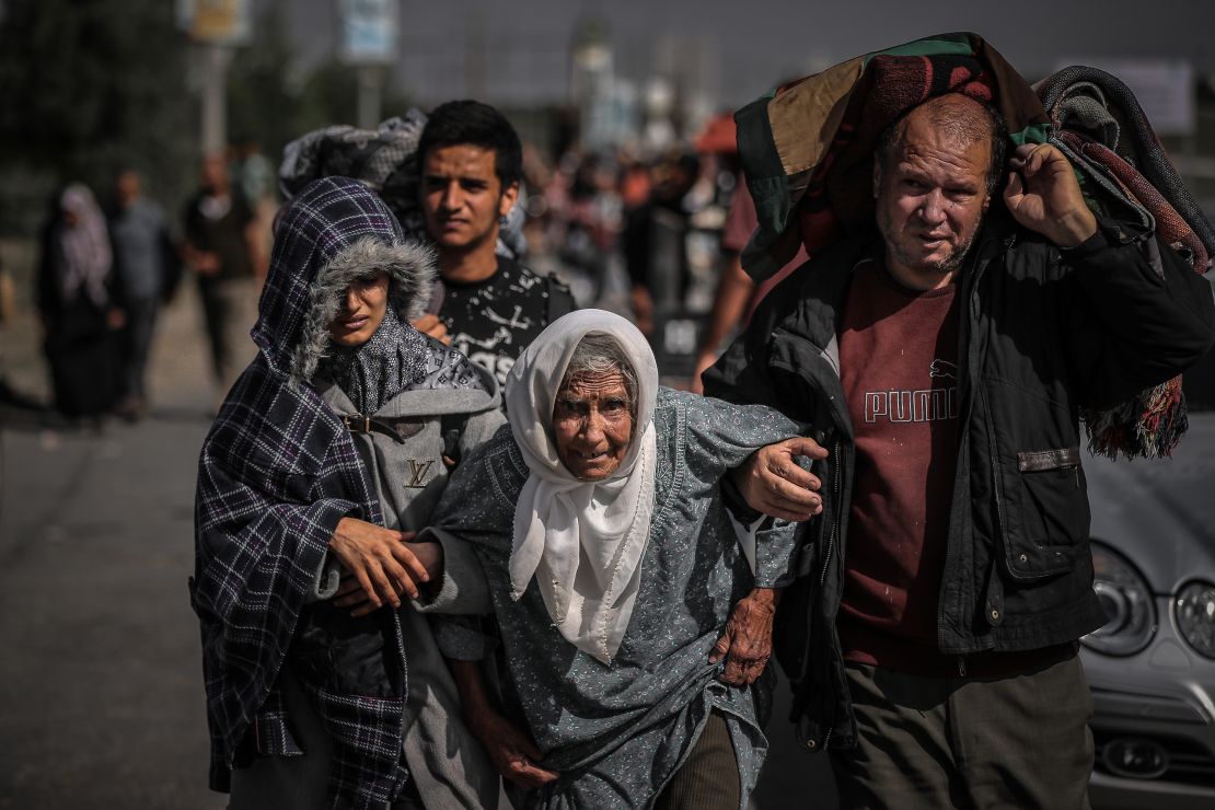 GAZA CITY, GAZA - NOVEMBER 10: Palestinians help elderly woman to walk as they leave from the northern part of the Gaza to flee the central and southern parts of the Gaza Strip on November 10, 2023. Since Oct.7, the Israeli army's attacks have caused significant damage in the northern part of the Gaza Strip, making it difficult for civilians living in the region. (Photo by Belal Khaled/Anadolu via Getty Images)