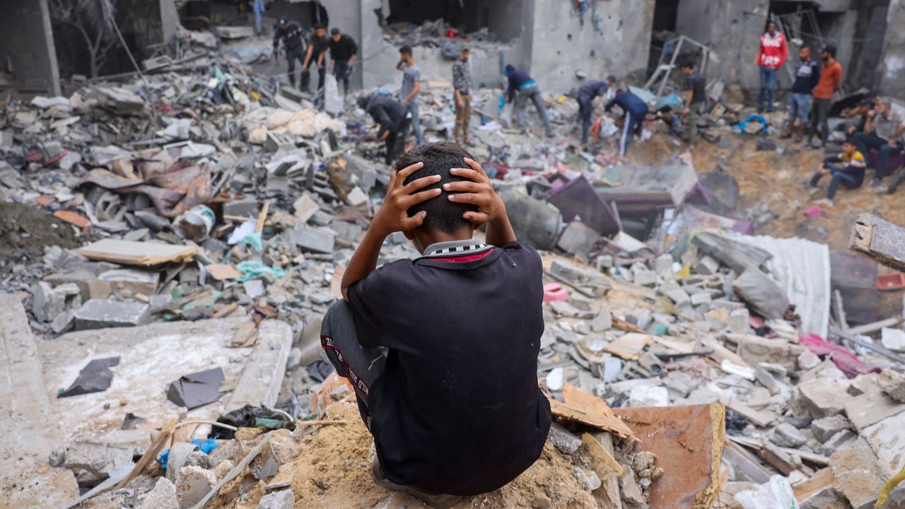 A child reacts as people salvage belongings amid the rubble of a damaged building following strikes on Rafah, Gaza, on November 12.