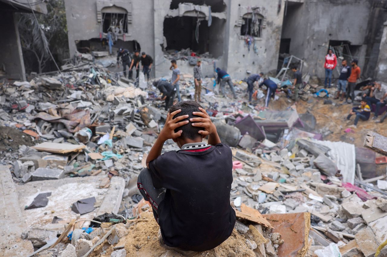 A child reacts as people salvage belongings amid the rubble of a damaged building following strikes on Rafah, Gaza, on November 12.