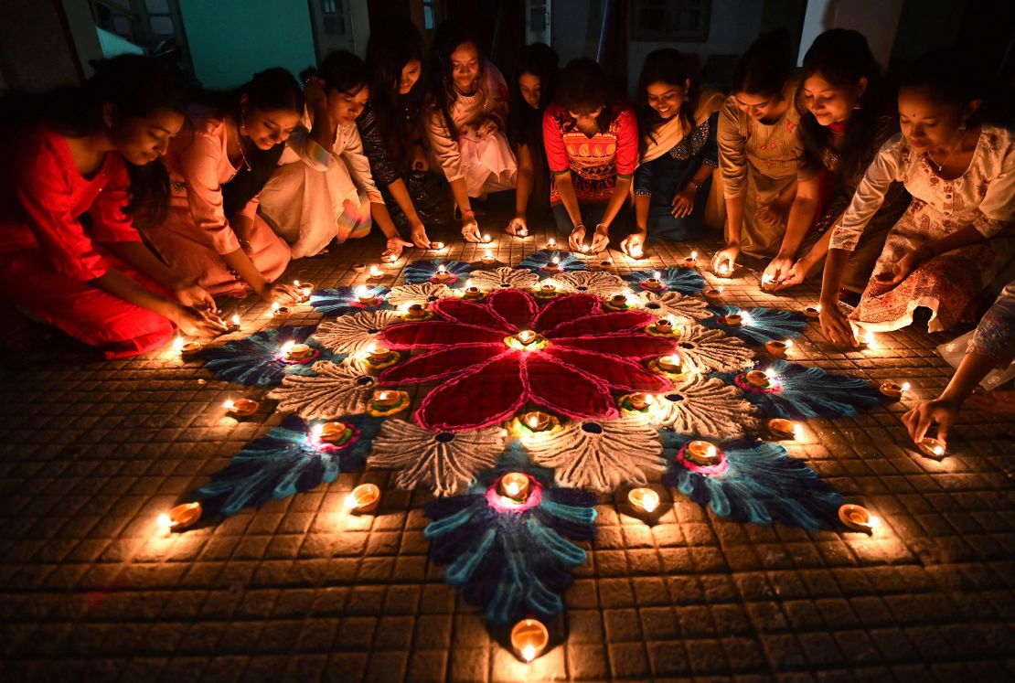 Students in the Indian city of Guwahati light oil lamps on a rangoli, a traditional Indian art form that is a staple of Diwali celebrations.