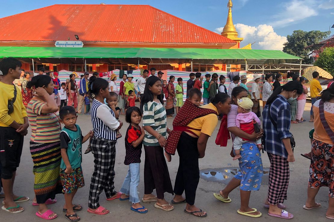 People queue for food at a monastery turned temporary shelter for internally displaced people in Lashio, Shan state on November 15, 2023.