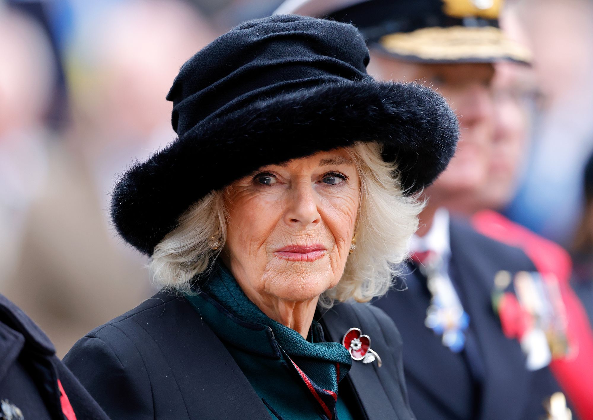 Queen Camilla will no longer buy clothes featuring fur. It is not clear whether the trim on the hat she wore here on Remembrance Day last year is real fur.