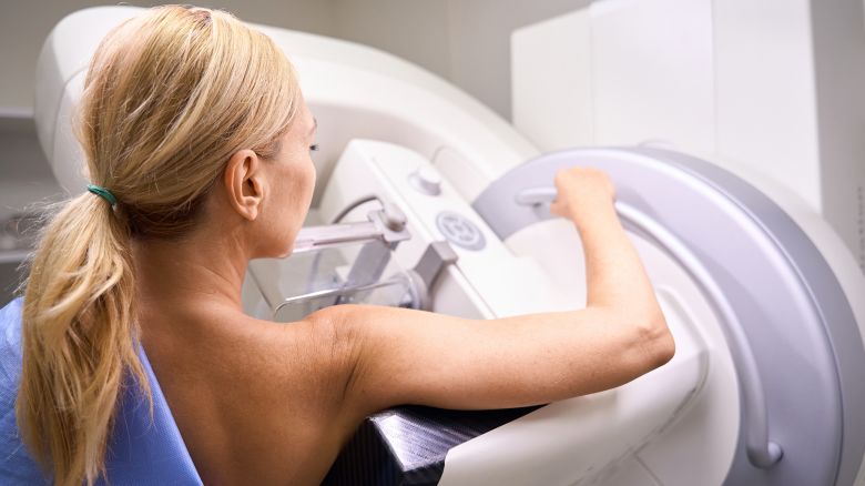 Back view of woman undergoing digital breast tomosynthesis on modern diagnostic equipment