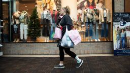 A shopper carries bags at the Polaris Fashion Place mall on Black Friday in Columbus, Ohio, US, on Friday, Nov. 24, 2023. An estimated 182 million people are planning to shop from Thanksgiving Day through Cyber Monday, the most since 2017, according to the National Retail Federation.