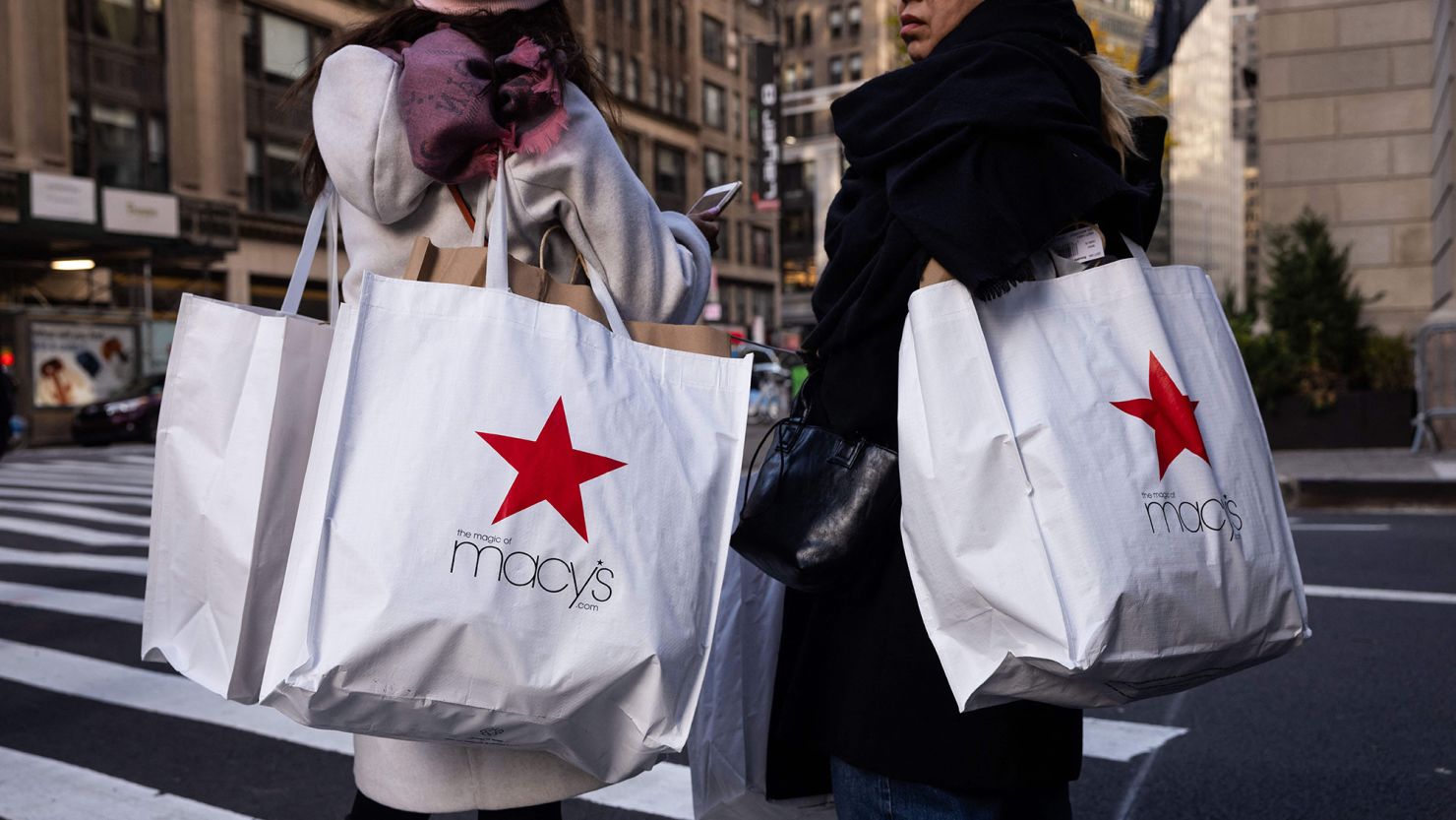 Shoppers carry Macy's bags during "Black Friday" in New York on November 24, 2023, the unofficial start of the holiday shopping season.