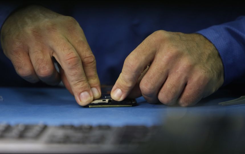 An employee assembles Motorola Solutions Inc. Moto X smartphones at the Flextronics International Ltd. factory in Fort Worth, Texas, in September 2013.