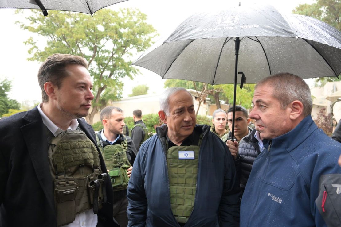 Israel's Prime Minister Benjamin Netanyahu (C) takes Elon Musk (L) on a tour of Kibbutz Kfar Azza.