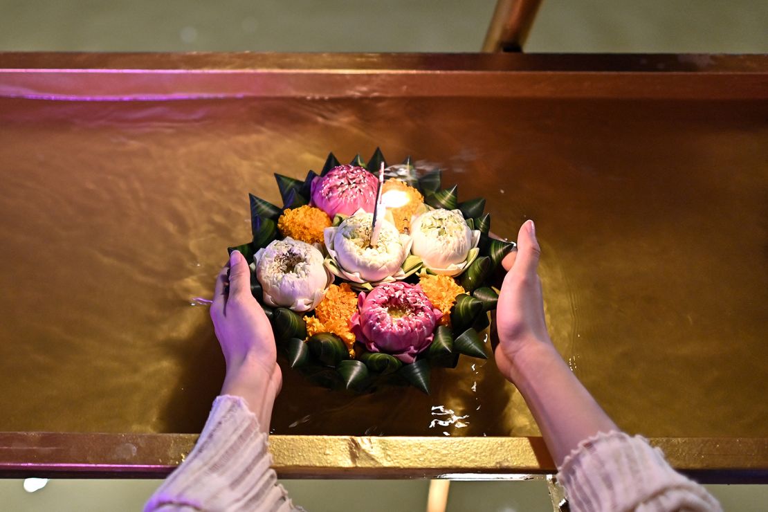 This photo taken in 2023 shows a woman releasing a "krathong" into the water in Bangkok.