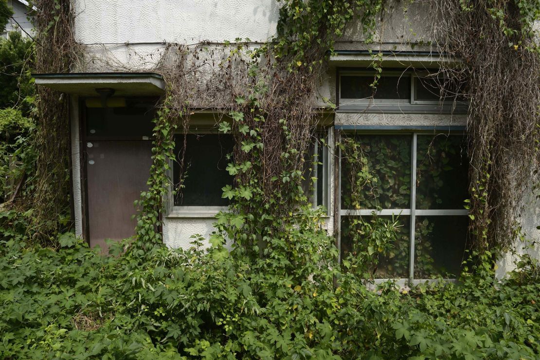 Overgrown vegetation surrounds a vacant house in the Yato area of Yokosuka City, Kanagawa prefecture, Japan, on August 21, 2013.