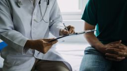 Male patient having consultation with doctor or psychiatrist who working on diagnostic examination on men's health disease or mental illness in medical clinic or hospital mental health service center