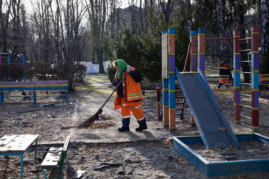 A municipal service worker sweeps up debris on the playground of a drone-damaged preschool in the Solomianskyi district of Kyiv, Ukraine, on November 25, 2023.
