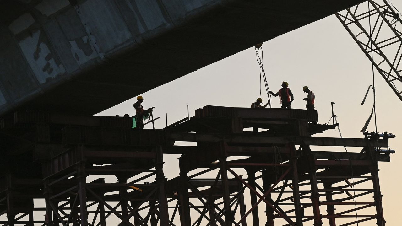 Labourers work at the costal road project construction site in Mumbai on November 30, 2023.