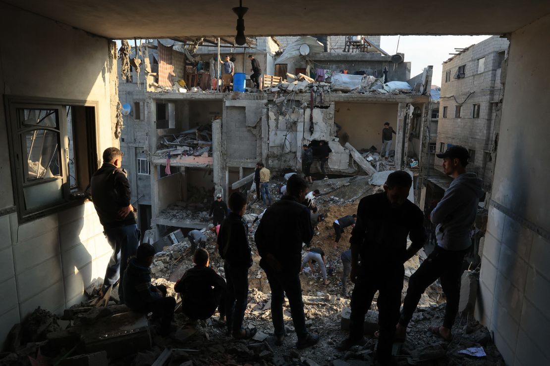 Palestinians inspect the destruction around residential buildings following Israeli air strikes in the Rafah refugee camp in southern Gaza on December 1, 2023.