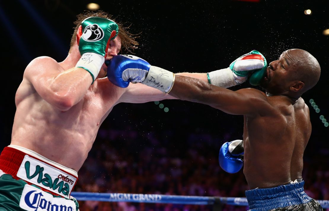 Floyd Mayweather Jr. y Canelo Álvarez intercambian golpes durante su pelea por el título de las 154 libras del CMB/AMB en el MGM Grand Garden Arena el 14 de septiembre de 2013 en Las Vegas, Nevada.