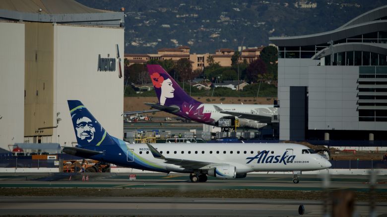 An Alaska Airlines and a Hawaiian Airlines airplane at Los Angeles International Airport (LAX) in Los Angeles, California, US, on Tuesday, Dec. 5, 2023.