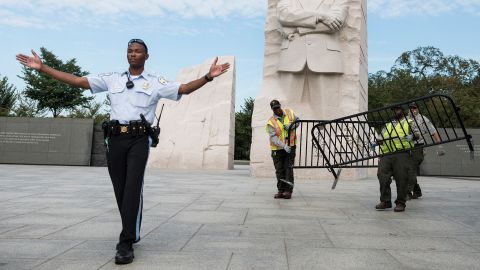 TOPSHOT - A US Park Police Officer and National Park Service employees close the Martin Luther King Jr. Memorial on the National Mall October 1, 2013 in Washington, DC. The US government is in a forced shutdown after lawmakers failed to pass a spending bill last night. AFP PHOTO/Brendan SMIALOWSKI (Photo by BRENDAN SMIALOWSKI / AFP) (Photo by BRENDAN SMIALOWSKI/AFP via Getty Images)          