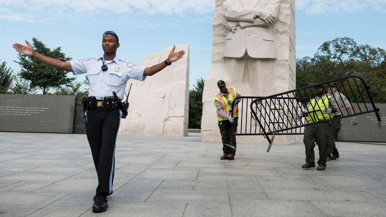 TOPSHOT - A US Park Police Officer and National Park Service employees close the Martin Luther King Jr. Memorial on the National Mall October 1, 2013 in Washington, DC. The US government is in a forced shutdown after lawmakers failed to pass a spending bill last night. AFP PHOTO/Brendan SMIALOWSKI (Photo by BRENDAN SMIALOWSKI / AFP) (Photo by BRENDAN SMIALOWSKI/AFP via Getty Images)          
