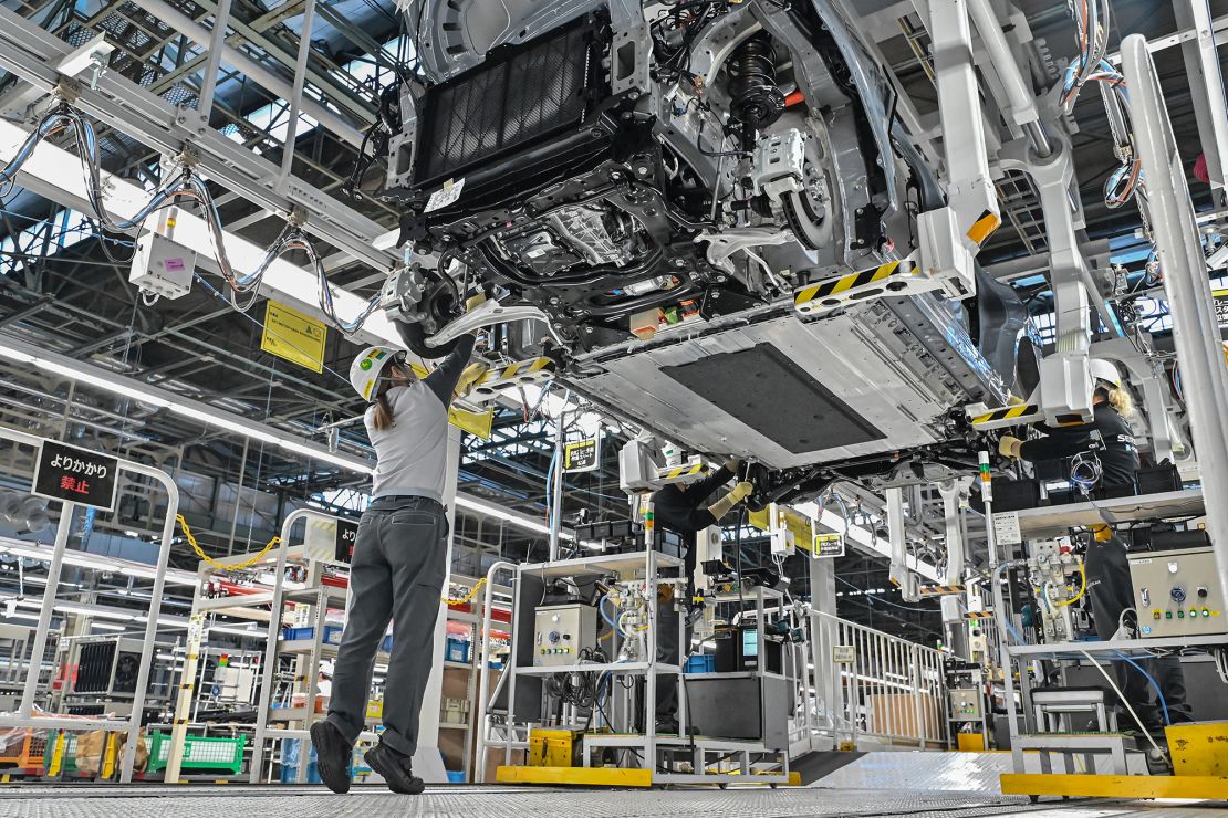 A worker checking a car on a Nissan production line.