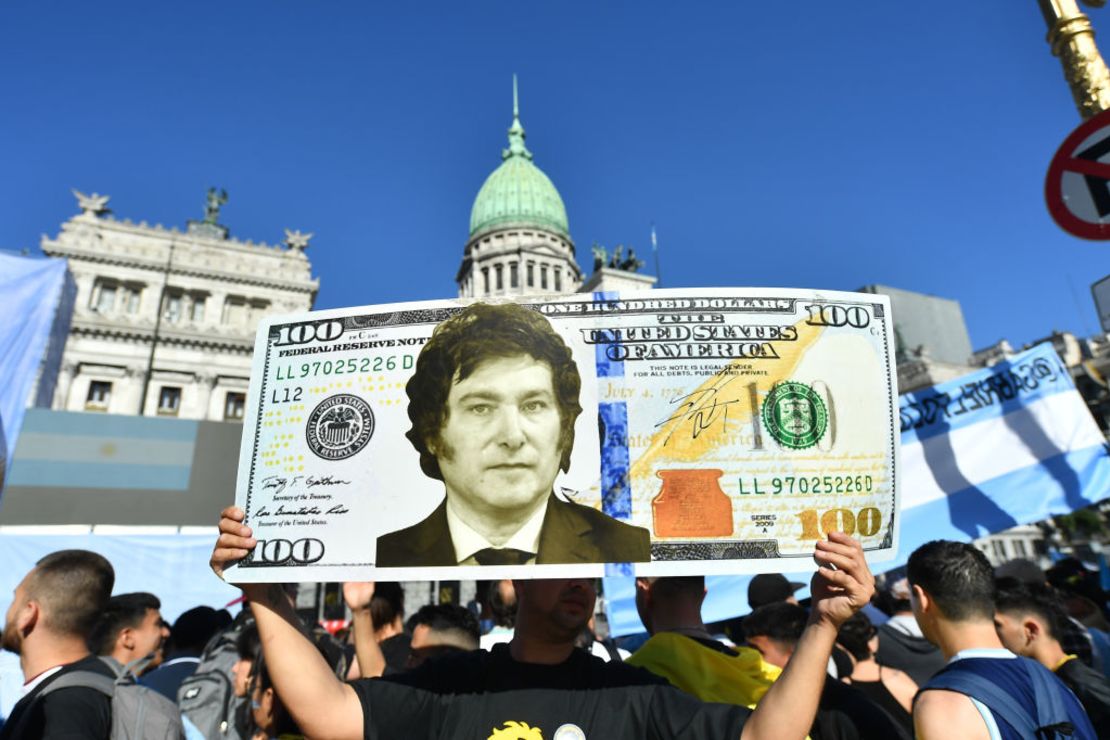Un simpatizante sostiene un billete de dólar gigante con la cara del presidente electo Javier Milei mientras la gente comienza a reunirse fuera del Congreso Nacional antes de su Ceremonia de Inauguración el 10 de diciembre de 2023 en Buenos Aires, Argentina.