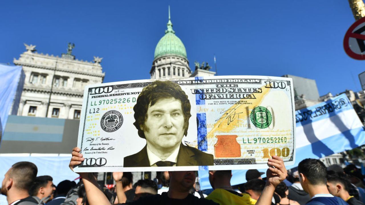 BUENOS AIRES, ARGENTINA - DECEMBER 10: A supporter holds a giant dollar bill with the face President elect Javier Milei as people start gathering outside National Congress ahead of during his Inauguration Ceremony on December 10, 2023 in Buenos Aires, Argentina. (Photo by Marcelo Endelli/Getty Images)