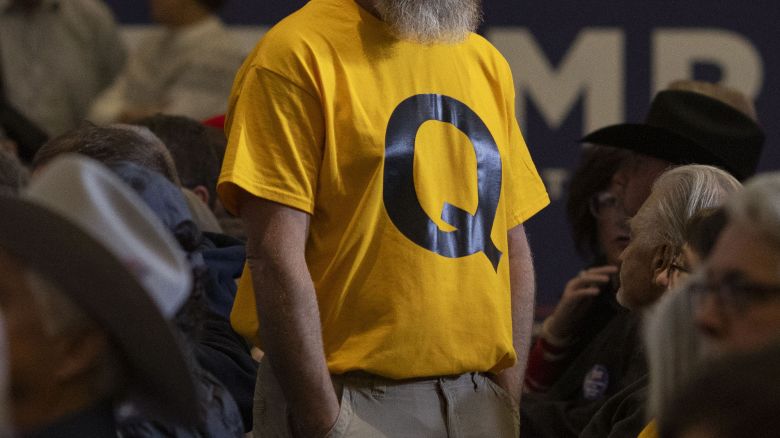 An attendee at a Trump presidential campaign rally wears a QAnon shirt. Trump has often stoked adherents of the wild conspiracy theory by promoting memes featuring Q iconography.