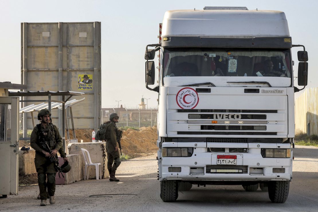 A truck carrying humanitarian aid provided by the Egyptian Red Crescent society moves past Israeli soldiers standing guard at the Israeli side of the Kerem Shalom border crossing with the southern Gaza Strip on December 19.
