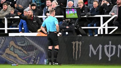 Referee Sam Barrott checks the pitch-side video assistant referee screen to review a yellow card given to Raúl Jiménez of Fulham during the Premier League match against Newcastle United on December 16, 2023.
