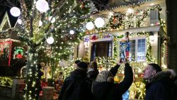 People look at homes decorated with Christmas lights and ornaments in Dyker Heights neighborhood, Brooklyn, New York City on December 20, 2023. (Photo by Charly TRIBALLEAU / AFP) (Photo by CHARLY TRIBALLEAU/AFP via Getty Images)