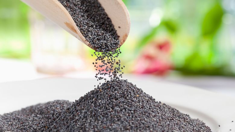blue poppy seeds, pooring from wooden shovel