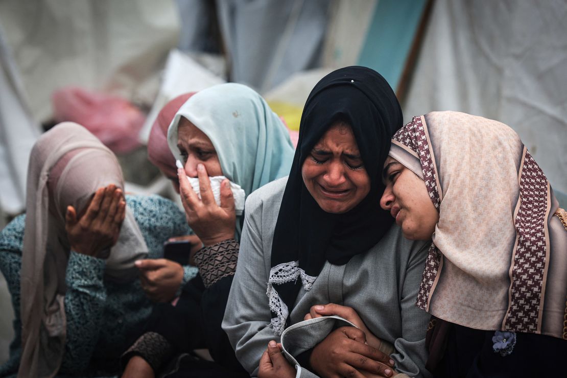 Palestinians mourn their relatives, killed in an overnight Israeli strike on the Al-Maghazi refugee camp, during a mass funeral at the Al-Aqsa hospital in Gaza on December 25, 2023.