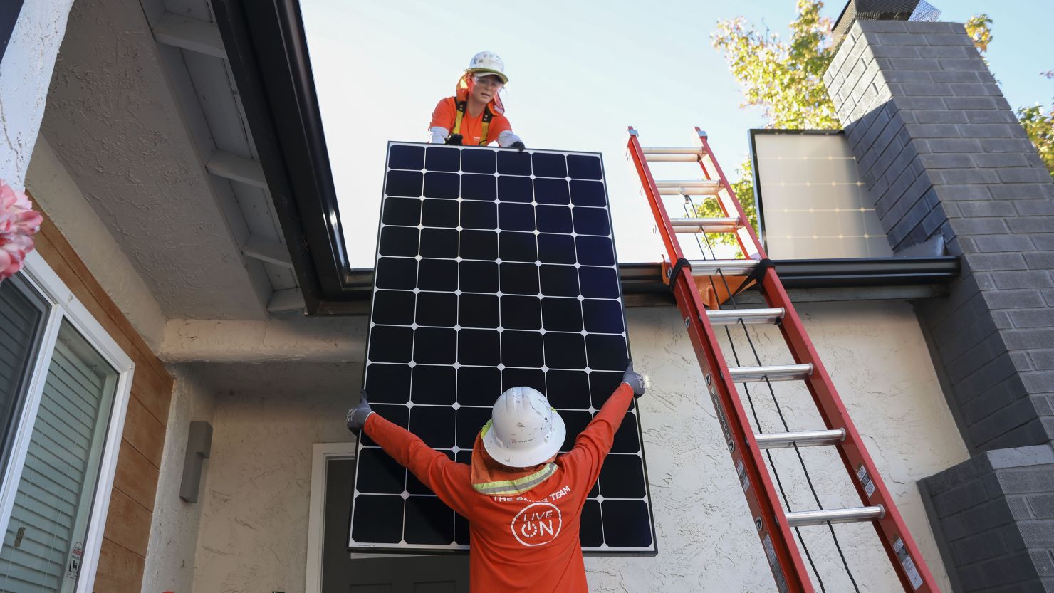 Workers install solar panels on the rooftop of a home in Poway, California, US, on Tuesday, Dec. 5, 2023. State subsidy cuts combined with high interest rates are slowing solar installations and costing green jobs. Photographer: Sandy Huffaker/Bloomberg via Getty Images