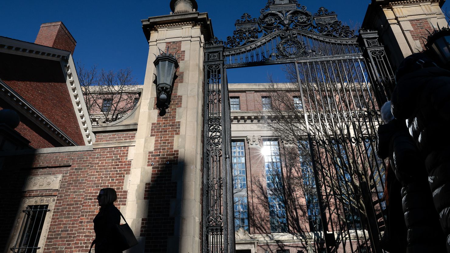A pedestrian passes a gate to Harvard Yard on Massachusetts Ave. in Cambridge, MA on December 12.