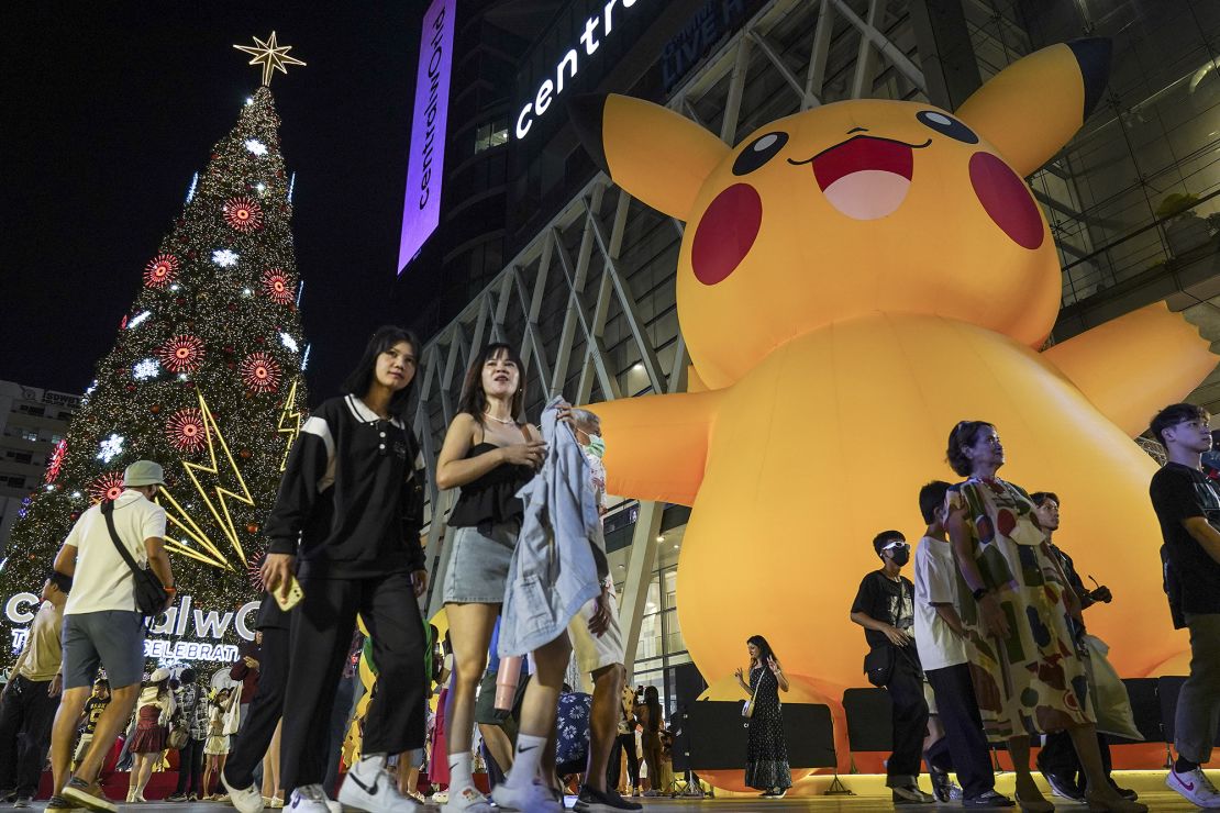 People are taking photographs with a large illuminated Christmas tree and inflatable Pikachu statues on display to welcome the year 2024 during New Year's Eve in Bangkok, Thailand, on December 31, 2023.