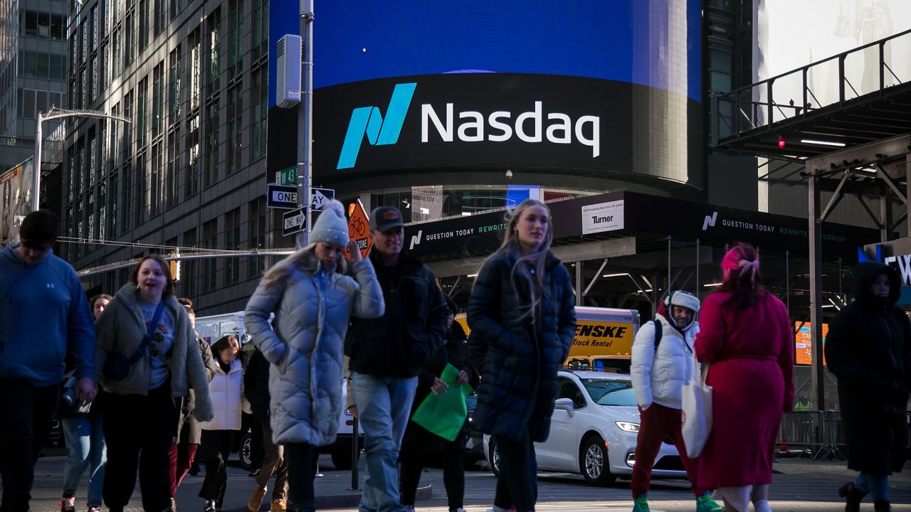 Pedestrians pass the Nasdaq MarketSite in New York.
