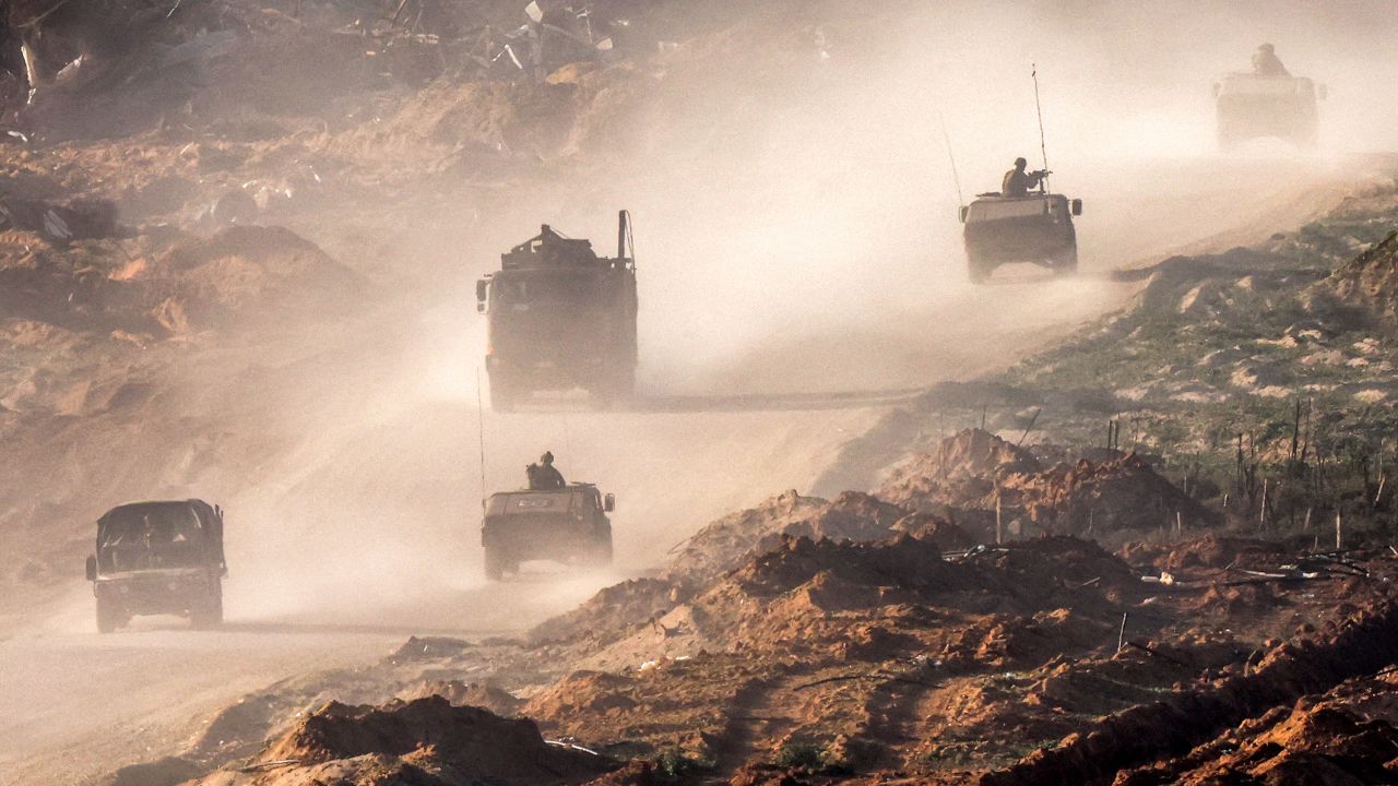 TOPSHOT - Israeli army humvees and vehicles move along a dirt road in the Gaza Strip near a position along the border with southern Israel on January 4, 2024, amid the ongoing conflict between Israel and the Palestinian militant group Hamas. (Photo by JACK GUEZ / AFP) (Photo by JACK GUEZ/AFP via Getty Images)