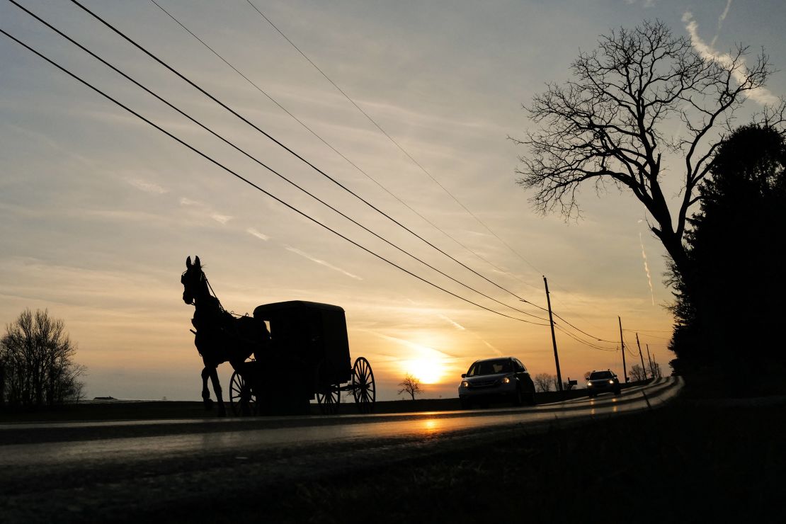 An Amish buggy shares the road with automobiles in Strasburg, Pennsylvania.