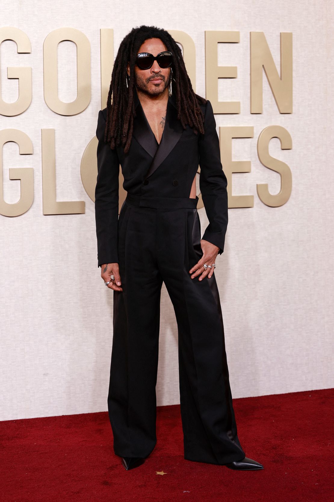 American singer Lenny Kravitz looked suave in a black Alexander McQueen tuxedo jumpsuit, Christian Louboutin shoes, Chrome Hearts diamond and gold rings and vintage ‘70s gold mesh earrings.