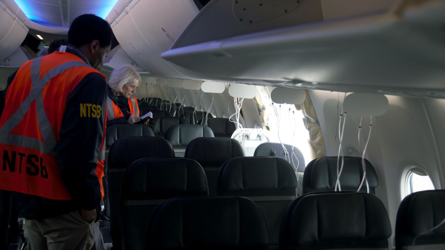 Members of the NTSB examine the hole in the fuselage plug area of Alaska Airlines Flight 1282 shortly after the flight.