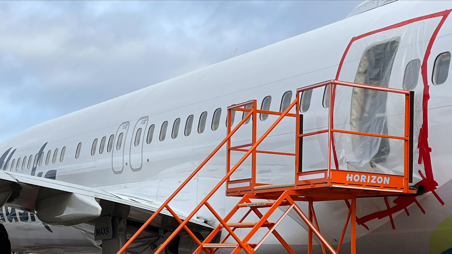 Plastic covers the exterior of the fuselage plug area of Alaska Airlines Flight 1282 Boeing 737-9 MAX on January 7, 2024.
