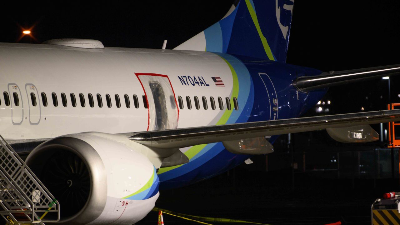 A plastic sheet covers an area of the fuselage of the Alaska Airlines Boeing 737 Max jet that lost its door plug during a January 2025 flight. One mother on the flight who had been holding her baby thought she had lost her son out the hole in the plane during the flight.