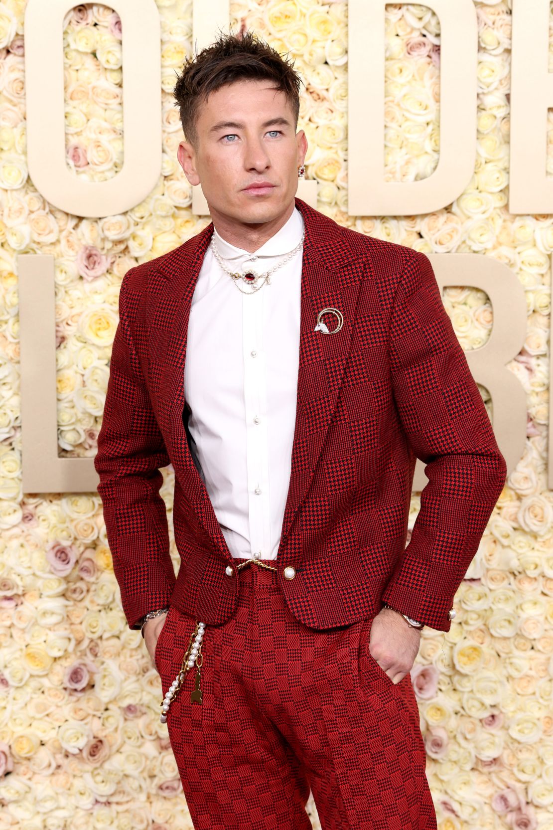 Barry Keoghan sported a red wool evening jacket in Louis Vuitton’s signature Damier pattern. He completed the look with checkered red pants from the label’s Spring-Summer 2024 collection, complete with a pearl belt chain, necklace, earring and a Tiffany & Co. broach.