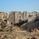 TOPSHOT - People walk in front of Gaza City's 17th century Qasr al-Basha or the Pasha's Palace on January 5, 2024, also known as Radwan dynasty castle, which houses a museum and a girls'school, damaged in Israeli bombardment during the ongoing battles between Israel and the Palestinian Hamas movement. The conflict triggered by Hamas's deadly October 7 attack on Israel has caused massive destruction in the Gaza Strip, killing tens of thousands and leaving residents on the brink of famine. Much of the territory has become unrecognisable, as entire neighbourhoods which were once bustling with people, cars and donkey-drawn carts have been reduced to rubble. (Photo by AFP) (Photo by -/AFP via Getty Images)