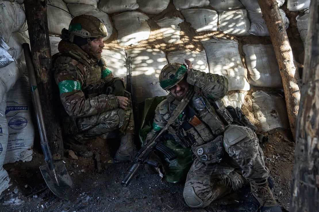 Ukrainian soldiers huddle under cover during artillery fire as the soldiers of Ukrainian National Guard hold their positions in the snow-covered Serebryan Forest on January 12, 2024 in Kreminna, Donetsk Oblast, Ukraine.